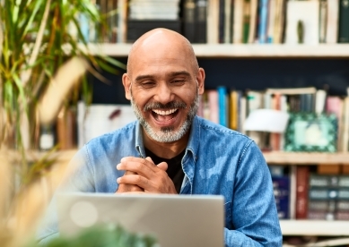 Mature man laughing and smiling on video conference